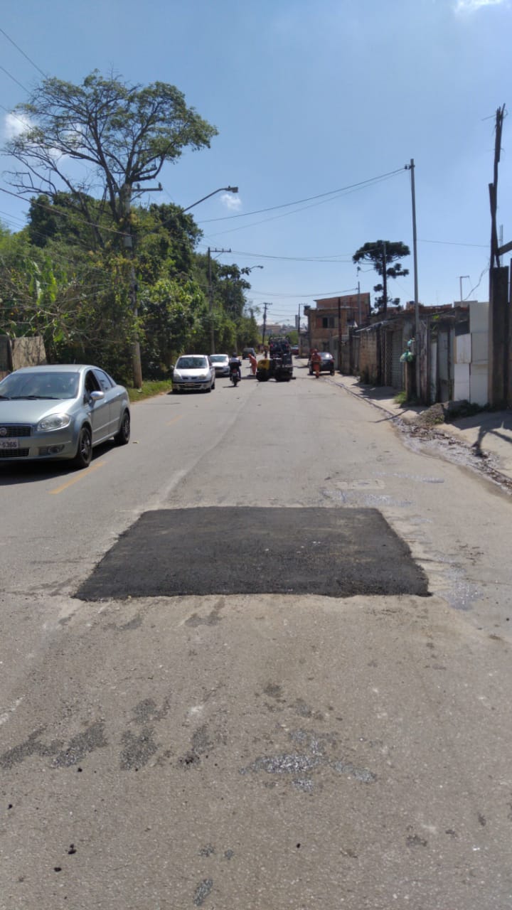 Buraco está fechado, com sinal de asfalto novo, em um quadrado, no meio da pista